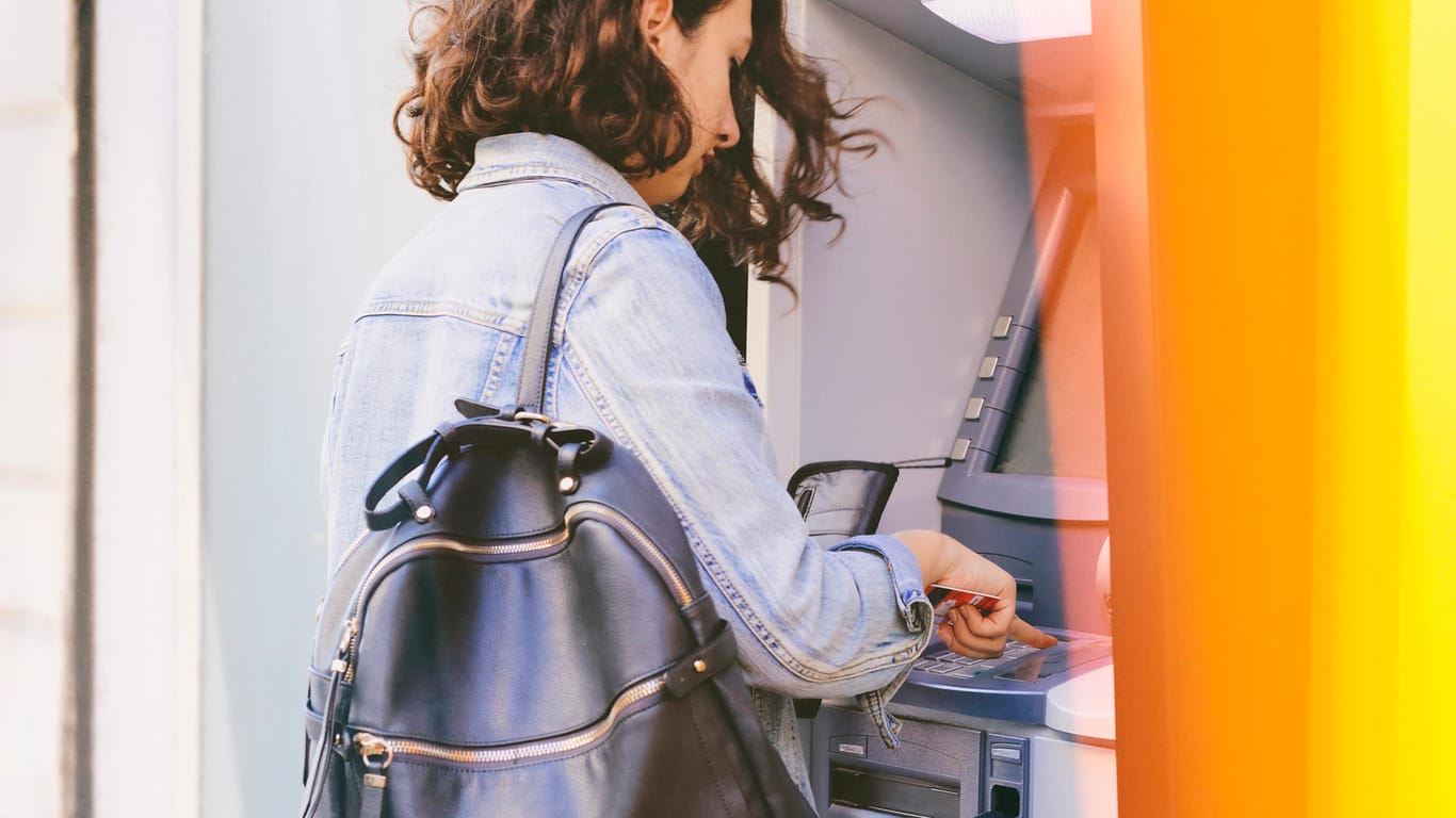 Eine Frau nutzt einen Geldautomaten (Symbolbild): Ein Basiskonto erfüllt grundlegende Funktionen wie das Abheben von Bargeld.