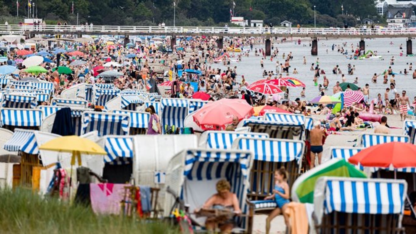 Badegäste geniessen im Juli den Nachmittag am Ostseestrand