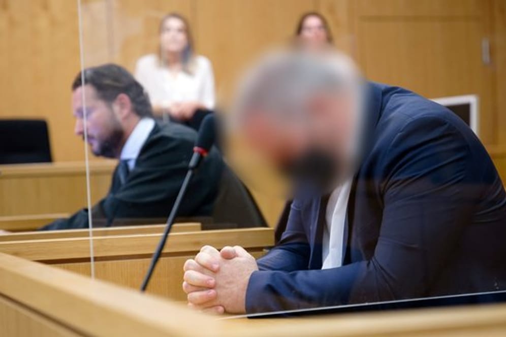 Der Angeklagte sitzt vor Beginn seines Prozesses in einem Saal des Aachener Landgerichts neben seinem Rechtsanwalt.