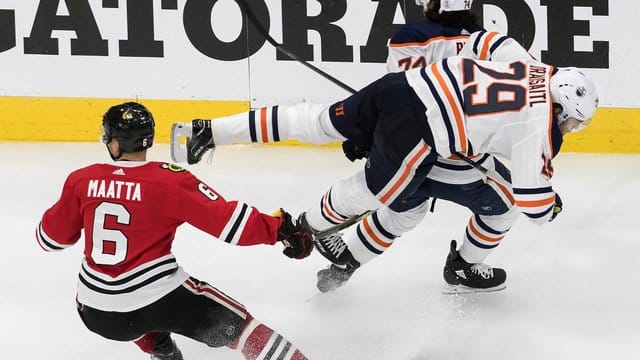 Edmontons Leon Draisaitl (r) wird durch Olli Maatta von den Chicago Blackhawks zu Fall gebracht. Edmontons Leon Draisaitl (r) wird durch Olli Maatta von den Chicago Blackhawks zu Fall gebracht.