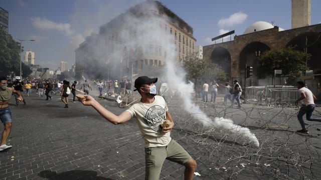 Ein Demonstrant wirft einen Stein auf Sicherheitskräfte.