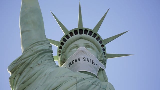 Eine riesige Maske ziert das Gesicht der Freiheitsstatue-Nachbildung in Las Vegas. Eine riesige Maske ziert das Gesicht der Freiheitsstatue-Nachbildung in Las Vegas.