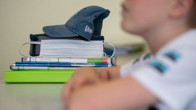 Eine Mund-Nasen-Bedeckung liegt während einer Unterrichtsstunde neben einem Schüler. Eine Mund-Nasen-Bedeckung liegt während einer Unterrichtsstunde neben einem Schüler.
