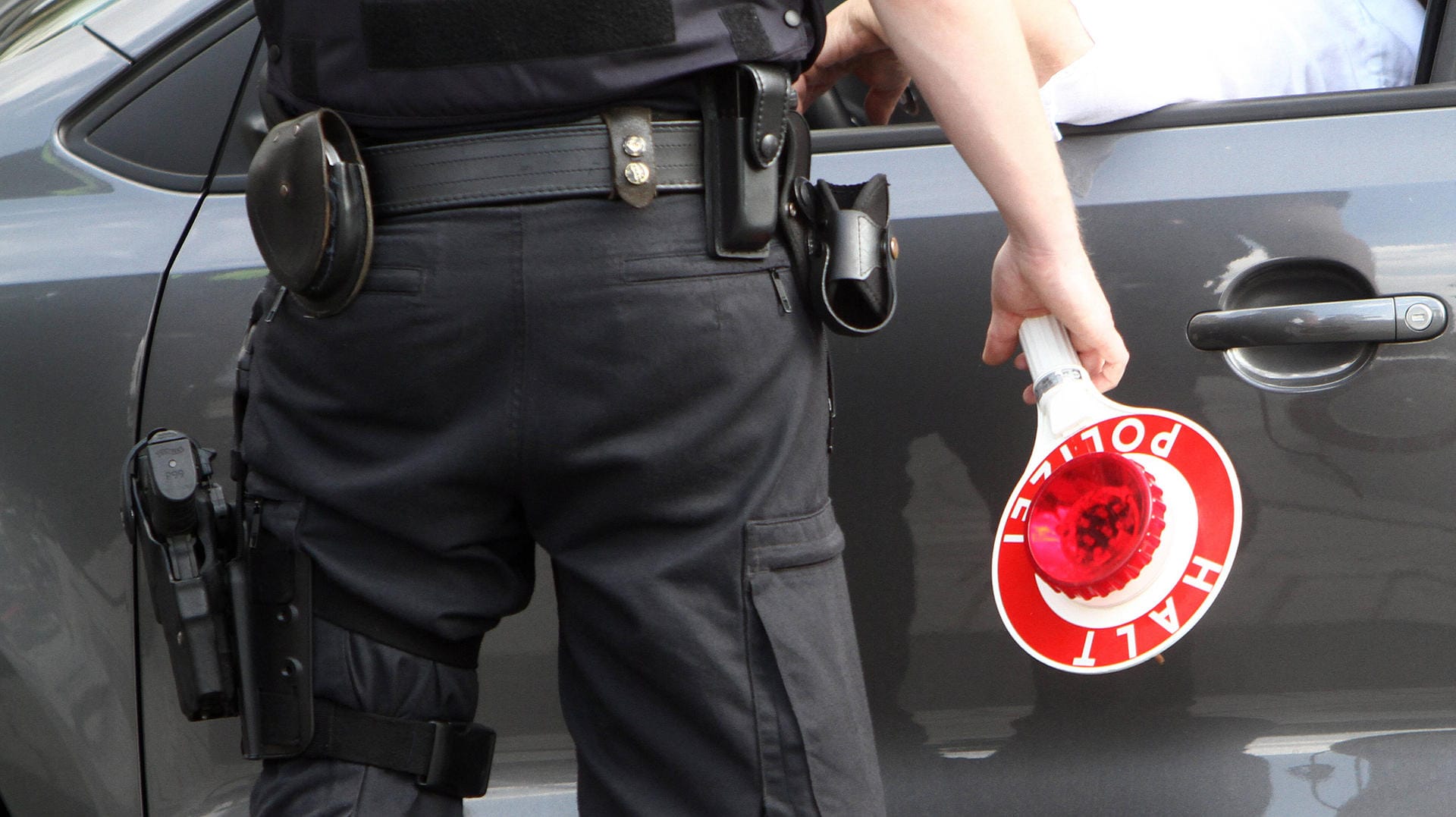 Ein Polizist hält eine Stoppkelle in der Hand (Symbolbild): In Düsseldorf kontrollierten die Beamten einen SUV-Fahrer – und wurden fündig. Ein Polizist hält eine Stoppkelle in der Hand (Symbolbild): In Düsseldorf kontrollierten die Beamten einen SUV-Fahrer – und wurden fündig.
