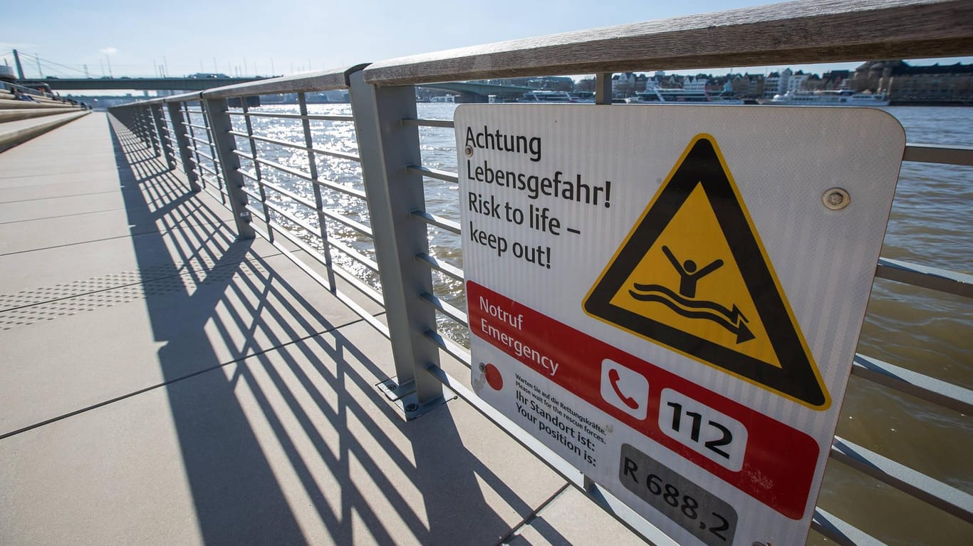Warnhinweise zur Lebensgefahr und Rettungsringe am Rheinboulevard in Köln: Beim Baden im Rhein ist eine 27-Jährige von der Strömung mitgerissen worden.
