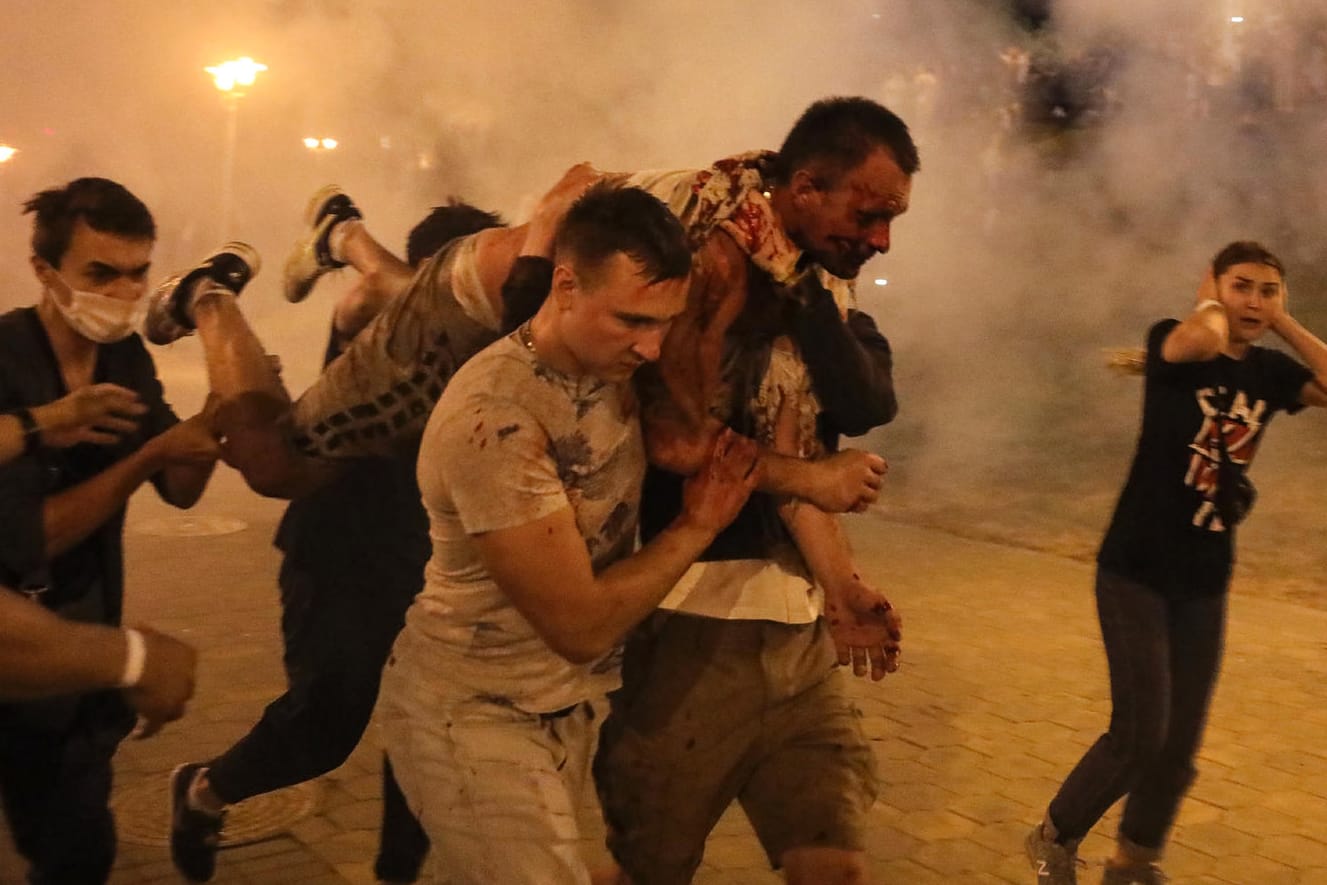 Demonstranten in Minsk tragen einen verletzten Mann davon: Die Polizei hat Tausende Menschen inhaftiert.