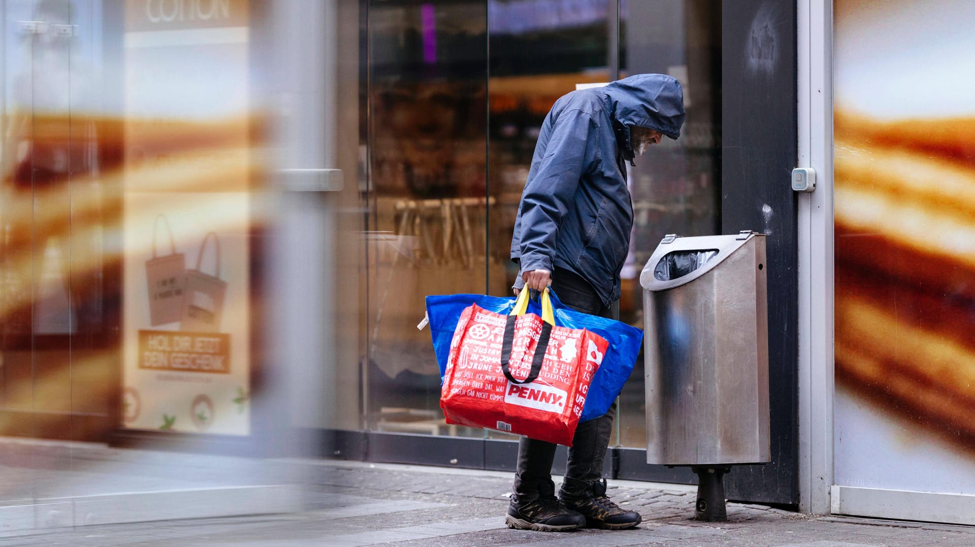 Ein Mann sucht in einem Mülleimer nach Pfandflaschen (Symbolbild): Besonders in Köln gibt es viele Wohnungs- und Obdachlose.