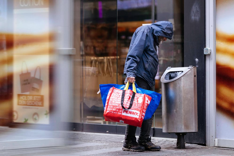 Ein Mann sucht in einem Mülleimer nach Pfandflaschen (Symbolbild): Besonders in Köln gibt es viele Wohnungs- und Obdachlose.