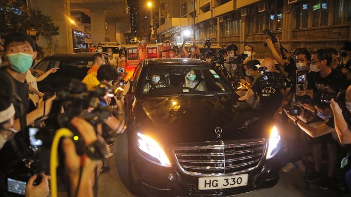 Jimmy Lai (Vordersitz, r) wird beim Verlassen des Polizeireviers von mehreren Dutzend Anhängern der Demokratiebewegung bejubelt.