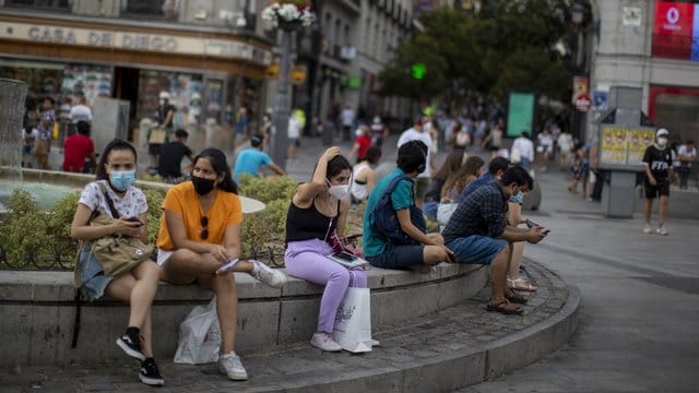 Menschen mit Masken in der Innenstadt von Madrid: Das Auswärtige Amt warnt wegen der Corona-Pandemie nun auch vor Reisen in Spaniens Hauptstadt.