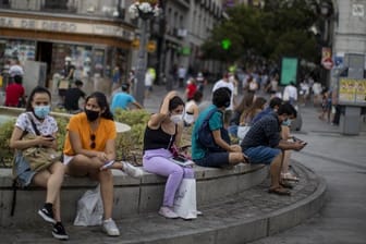 Menschen mit Masken in der Innenstadt von Madrid: Das Auswärtige Amt warnt wegen der Corona-Pandemie nun auch vor Reisen in Spaniens Hauptstadt.