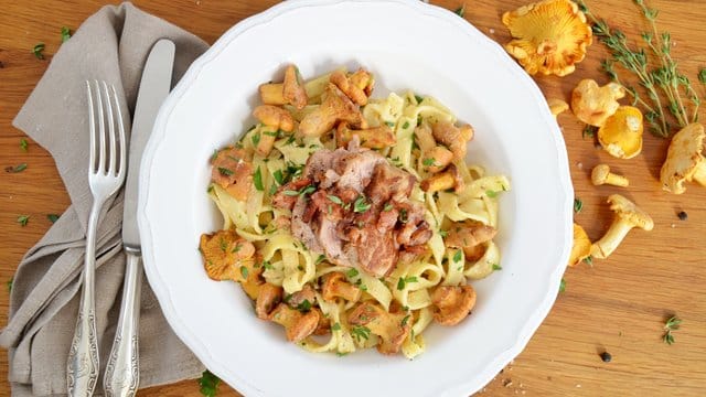 Pfifferlinge werden hier zusammen mit Tagliatelle, Schweinefilet und Bacon serviert.