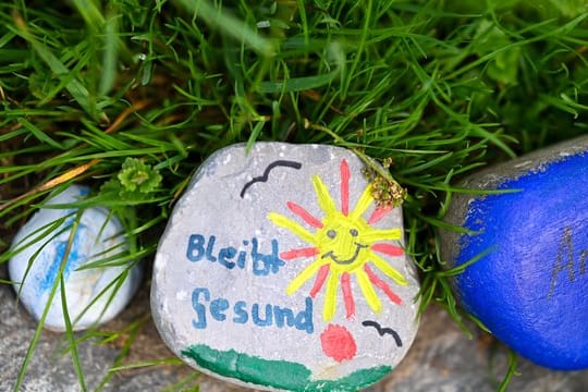 Bemalte Steine an einem Wegesrand.