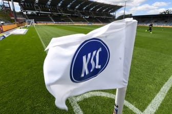 Eine Flagge mit dem Logo von Karlsruher SC ist im Stadion mit leeren Tribünen zu sehen.