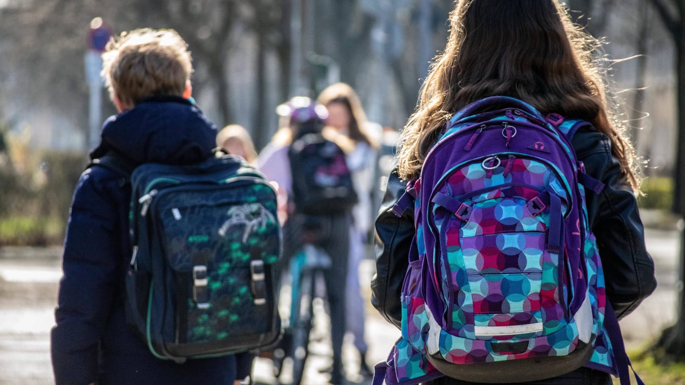 Schulkinder tragen Ranzen: In zwei Berliner Schulen soll es bereits Corona-Fälle geben, Schüler wurden nach Hause geschickt.