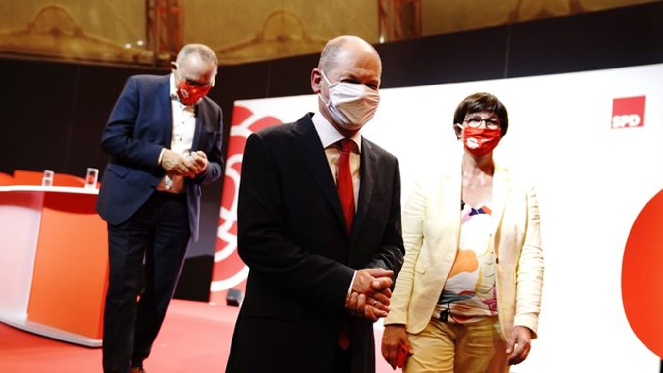 Bundesfinanzminister Olaf Scholz (M) nach seiner Vorstellung als Kanzlerkandidat der SPD durch die Parteichefs Norbert Walter-Borjans (l) und Saskia Esken.