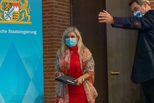 Melanie Huml (l, CSU), Staatsministerin für Gesundheit und Pflege, und Markus Söder (CSU), Ministerpräsident von Bayern, auf dem Weg zu einer gemeinsamen Pressekonferenz.