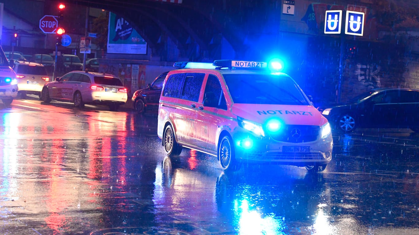 Ein Notarztwagen überquert die nasse Straße nach Bad Godesberg, die wegen eines Unwetters gesperrt worden war: Wegen des Unwetters waren zahlreiche Rettungskräfte im Einsatz.