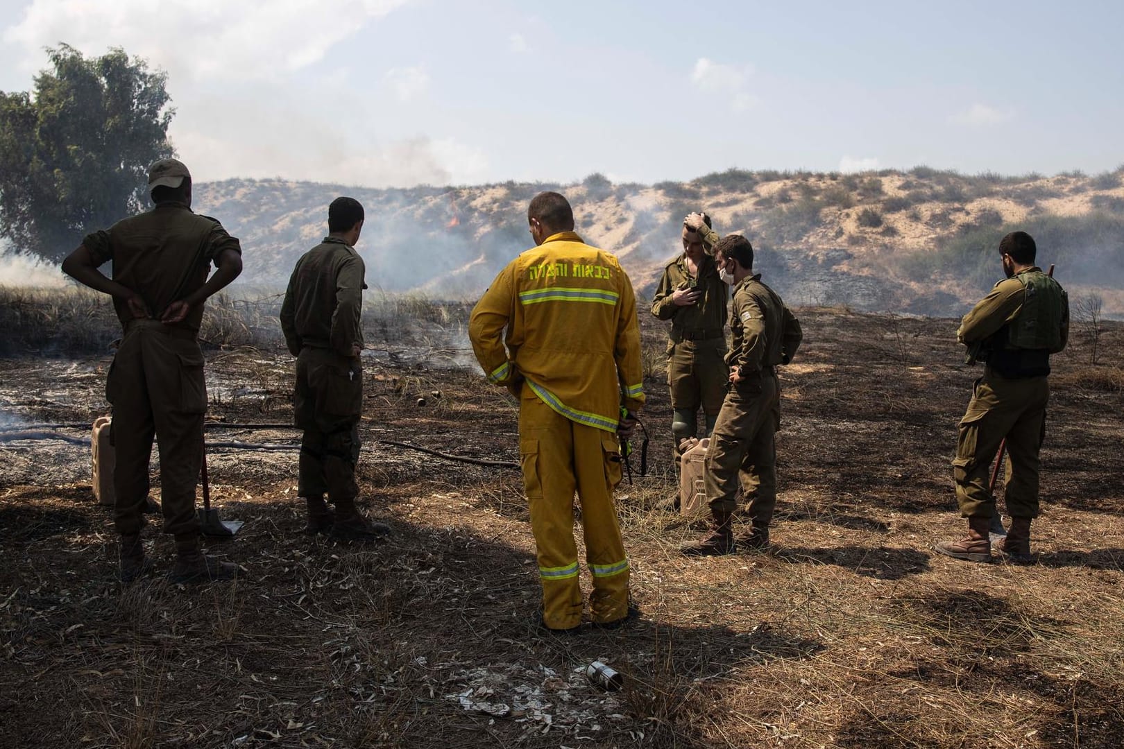 Soldaten und Einsatzkräfte der Feuerwehr löschen Brände, die bei Angriffen aus dem Gaza-Streifen ausgelöst wurden.