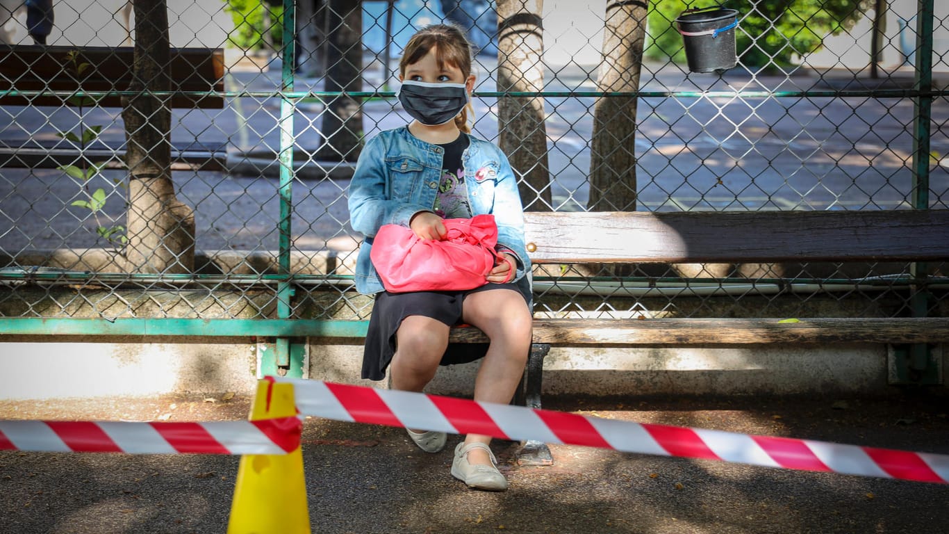 Ein junges Mädchen mit einer Maske (Symbolbild): In Essen hat die erste Grundschule wegen Corona-Fällen schließen müssen.