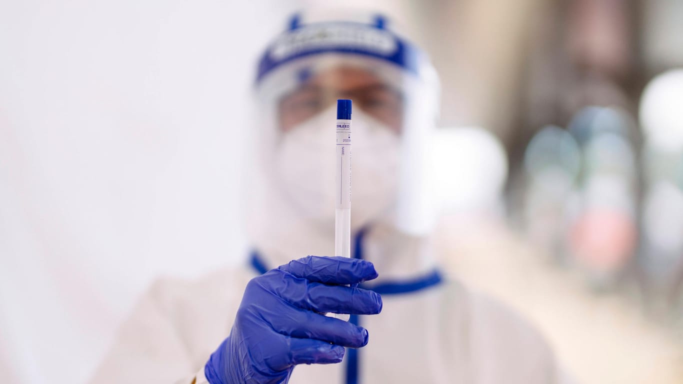 Ein Mitarbeiter eines Corona-Testzentrums hält einen Corona-Test in die Höhe (Symbolbild): In Bielefeld ist es zuletzt zu steigenden Infektionszahlen gekommen.