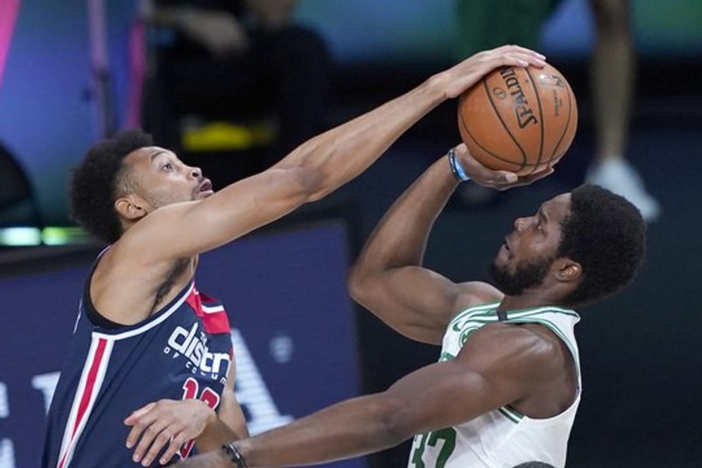 Jonathan Williams (l) von den Washington Wizards blockt einen Wurf von Semi Ojeleye von den Boston Celtics.
