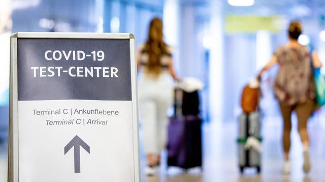 Ein Schild weist Reisende auf das Corona-Testzentrum am Flughafen Hannover-Langenhagen hin. Ein Schild weist Reisende auf das Corona-Testzentrum am Flughafen Hannover-Langenhagen hin.