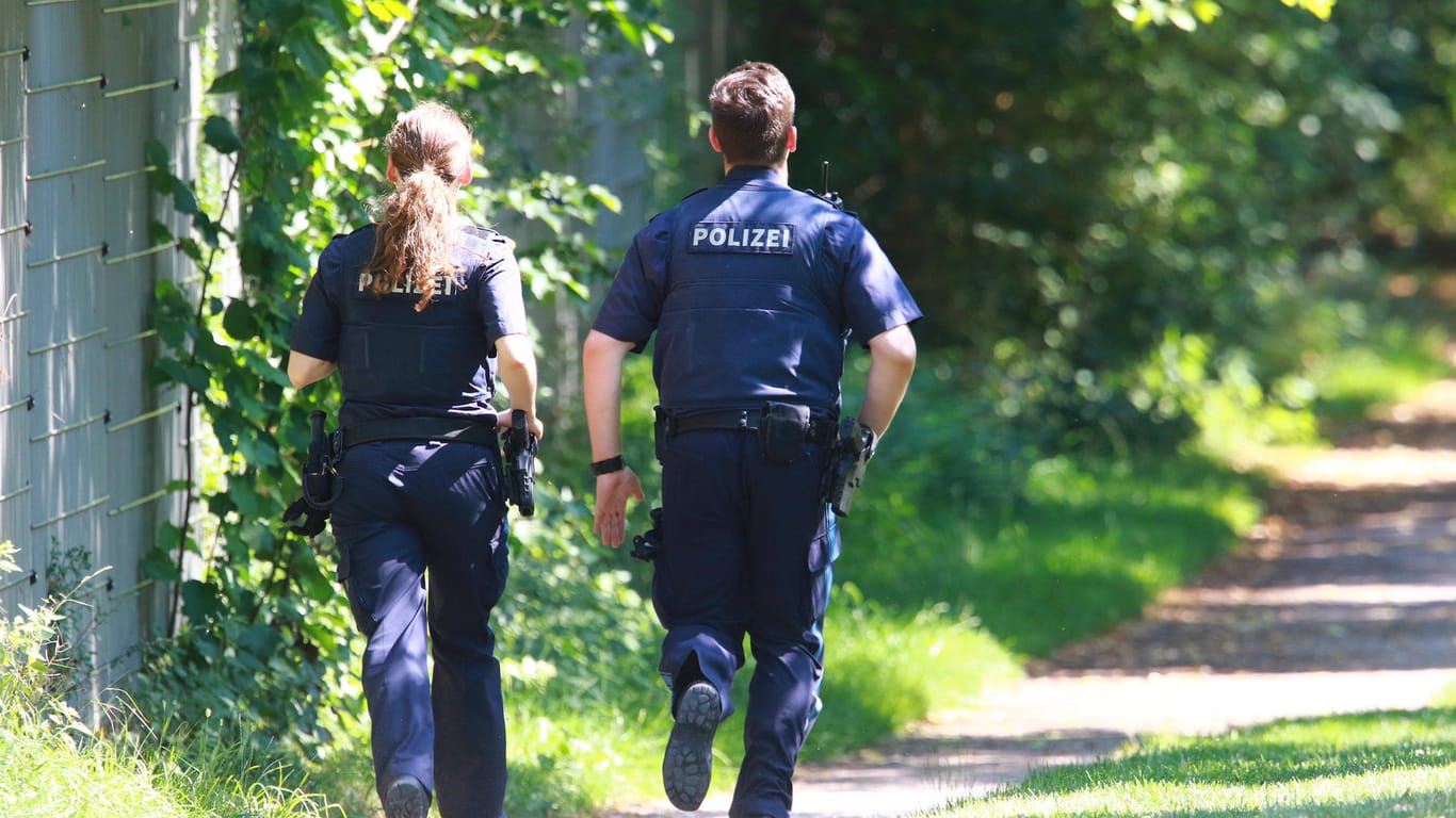 Polizeibeamte laufen im Park (Symbolbild): In München hat ein Mann sein Blut als Waffe gegen die Polizei eingesetzt.