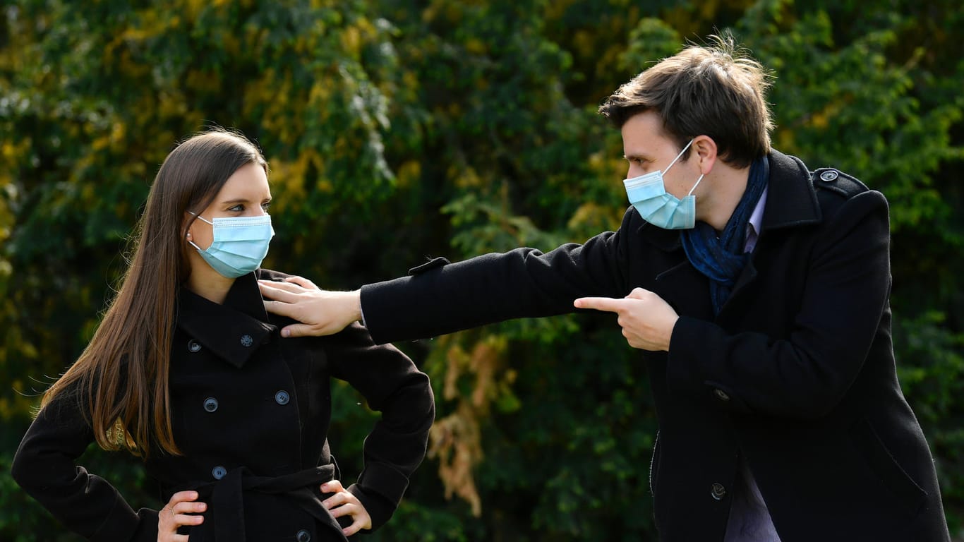 Eine Frau und ein Mann mit Mundschutzmaske: Wegen der Corona-Pandemie sollen Menschen mehr Abstand zu anderen einhalten.