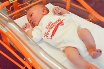 Ein Baby trägt einen Strampler mit der Aufschrift "Unser Neuzugang": Der 1. FC Nürnberg hofft auf die Fans von übermorgen.
