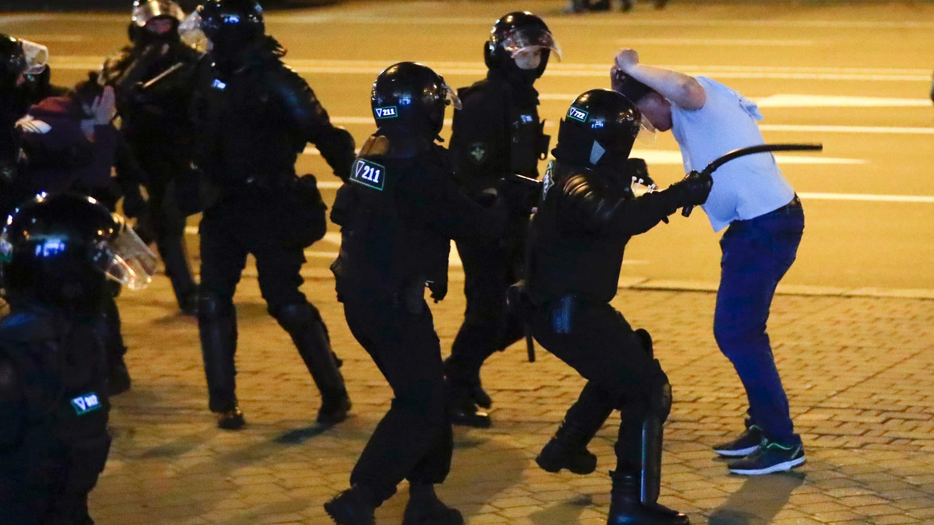 Proteste in Minsk: Polizisten attackieren einen Demonstranten, einer von ihnen holt zum Schlag mit einem Schlagstock aus.