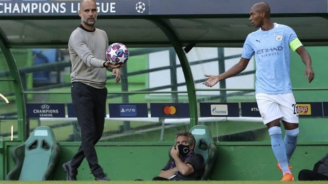 Manchester Citys Trainer Pep Guardiola (l) übergibt den Ball zur Ausführung eines Einwurfes an Fernandinho.