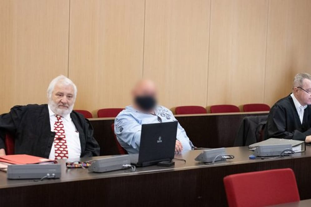 Der Angeklagte (M) sitzt zwischen seinen Anwälten