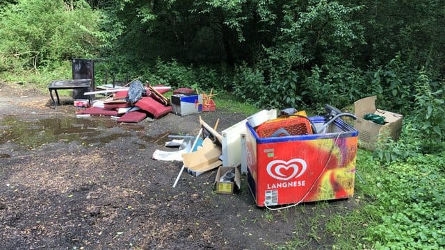 Illegal entsorgter Müll neben einem Wald: Die Müllkippen sind für den heimischen Wald und Tiere gefährlich.