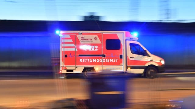 Ein Rettungswagen fährt mit Blaulicht über eine Straße: Ein Kontrolleur wurde in einem ICE mit einem Messer attackiert. Ein Rettungswagen fährt mit Blaulicht über eine Straße: Ein Kontrolleur wurde in einem ICE mit einem Messer attackiert.