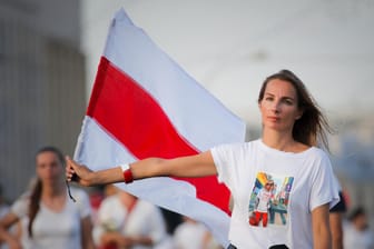 Eine Frau mit der alten belarussischen Flagge: Es sind die Frauen des Landes, die die Protestbewegung ins Rollen gebracht haben.