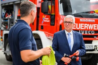 Roger LewentzRoger Lewentz (rechts) unterhält sich mit einem Feuerwehrmann: Die Feuerwehren im Land bekommen neue Spezialfahrzeuge.