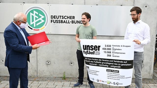 Jan-Henrik Gruszecki (r) und Manuel Gaber (M) von der Fan-Initiative "Unser Fußball" übergeben eine Erklärung zur geforderten Reform an DFB-Präsident Fritz Keller. Jan-Henrik Gruszecki (r) und Manuel Gaber (M) von der Fan-Initiative "Unser Fußball" übergeben eine Erklärung zur geforderten Reform an DFB-Präsident Fritz Keller.