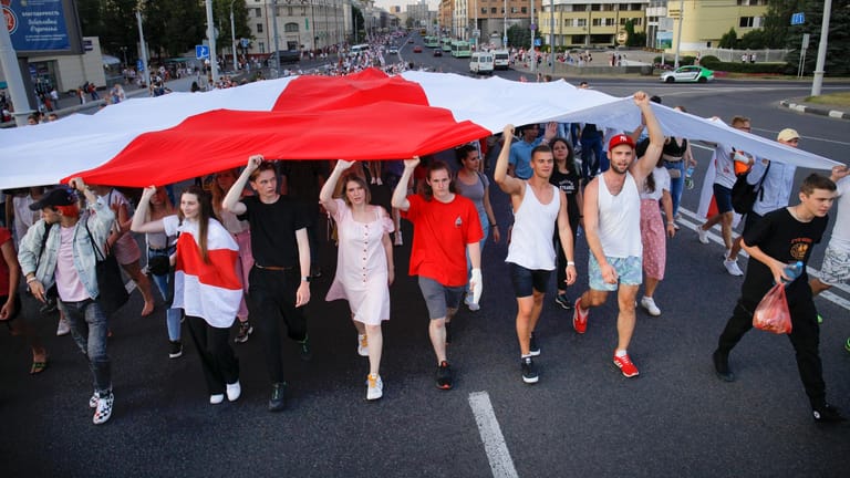 Misnk: Demonstranten, die in Belarus gegen Präsident Lukaschenko protestieren, tragen eine rot-weiße Flagge.