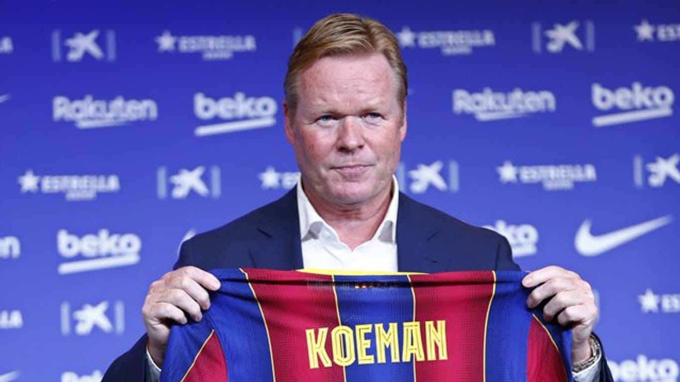 Ronald Koeman zeigt bei seiner offiziellen Vorstellung als Trainer des FC Barcelona ein Fussballtrikot mit seinem Namen darauf.