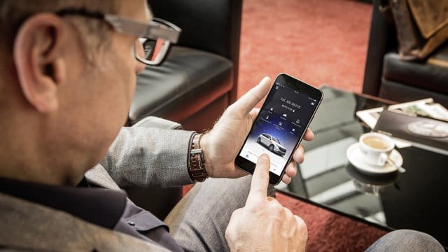 Ein Mercedes-Fahrer startet die Me-App.