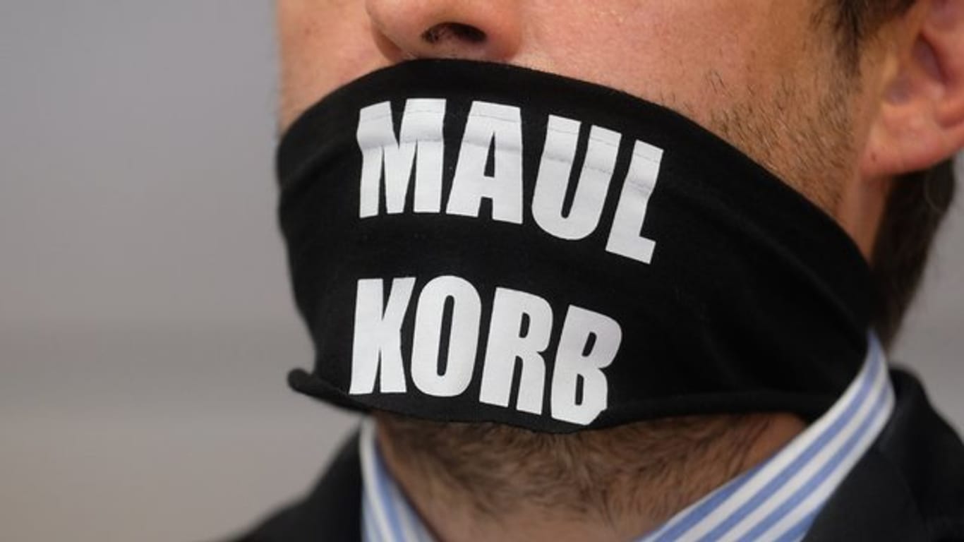 Sven Liebich trägt im Gerichtssaal in Halle einen Mundschutz mit der Aufschrift "Maulkorb".