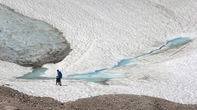Zwei Wanderer gehen über den Schneeferner-Gletscher auf der Zugspitze. Zwei Wanderer gehen über den Schneeferner-Gletscher auf der Zugspitze.