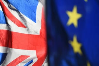 Eine Flagge der Europäischen Union und eine Flagge von Großbritannien wehen vor dem Parlament in Westminster.