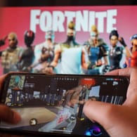 Ein Kind spielt auf seinem Smartphone (Symbolbild): "Fortnite" gehört zu einem der aktuell erfolgreichsten Spiele.