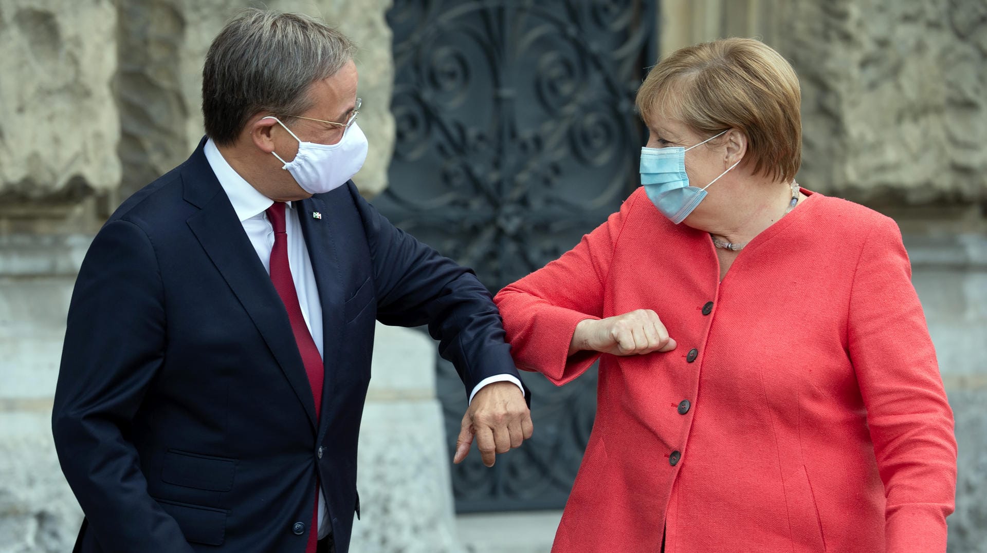 Corona-Gruß in Düsseldorf: Kanzlerin Merkel wurde von Ministerpräsident Laschet erstmals zu einer Sitzung des NRW-Landeskabinetts eingeladen.
