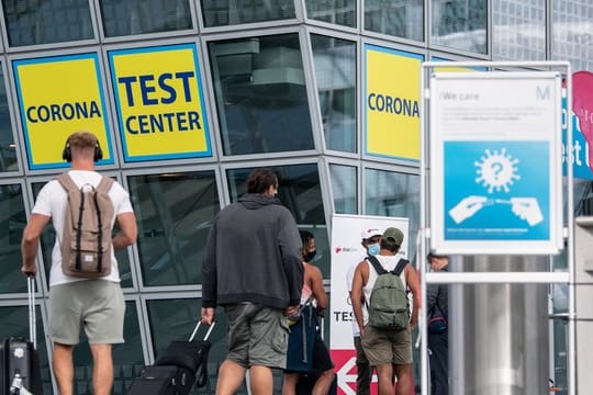 Ankommende Fluggäste gehen zu einem Corona- Testcenter am Flughafen München.