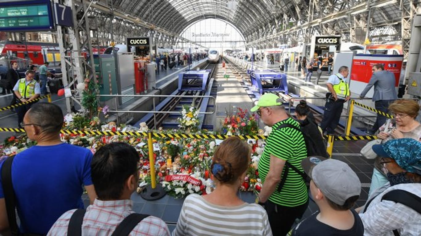 Passanten stehen 2019 im Frankfurter Hauptbahnhof vor Blumen, Kuscheltieren und Beileidsbekundungen.