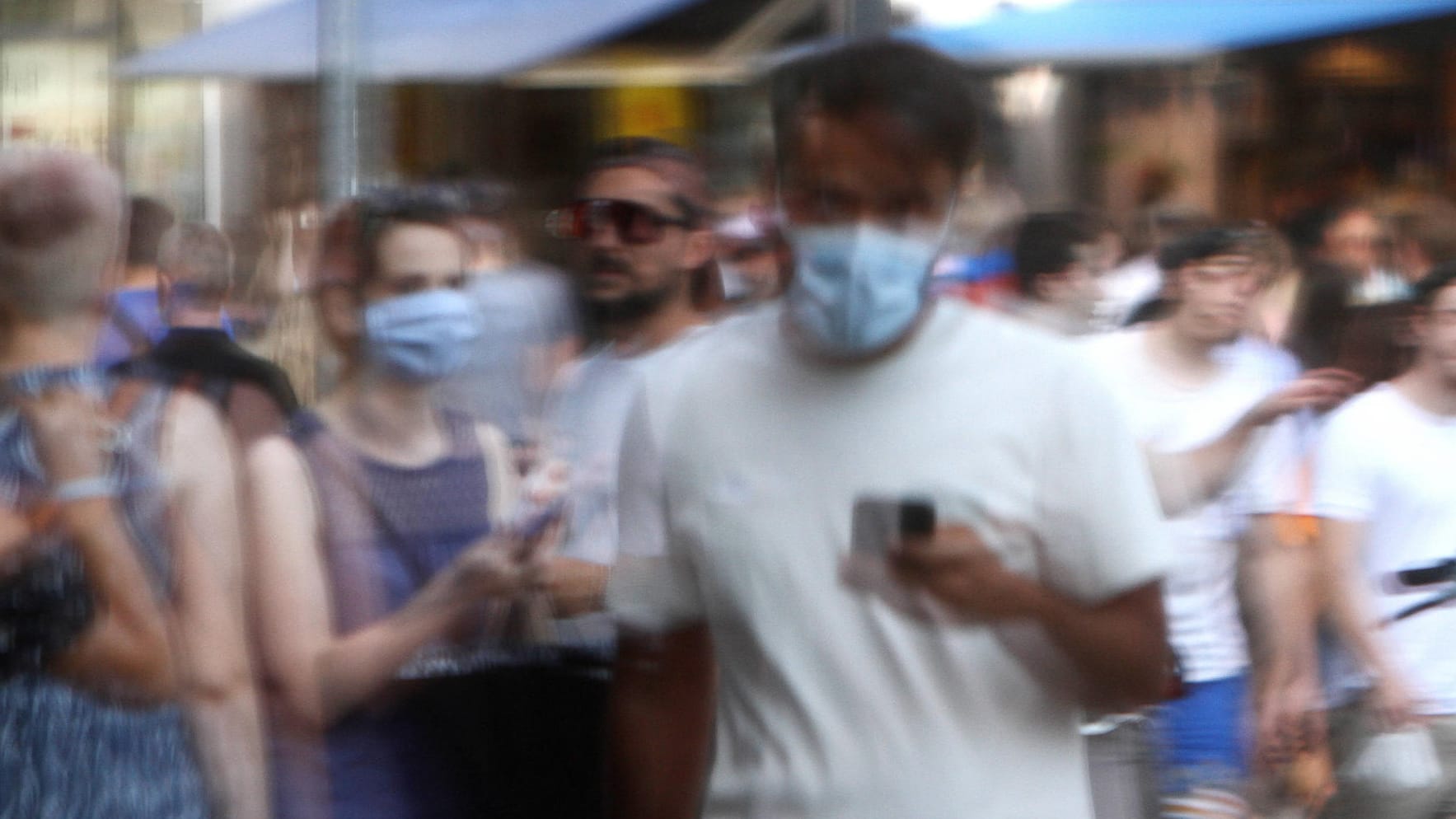 Passanten spiegeln sich in einem Schaufenster: Das Coronavirus verbreitet sich auf dem Land und in der Stadt ähnlich stark. Passanten spiegeln sich in einem Schaufenster: Das Coronavirus verbreitet sich auf dem Land und in der Stadt ähnlich stark.