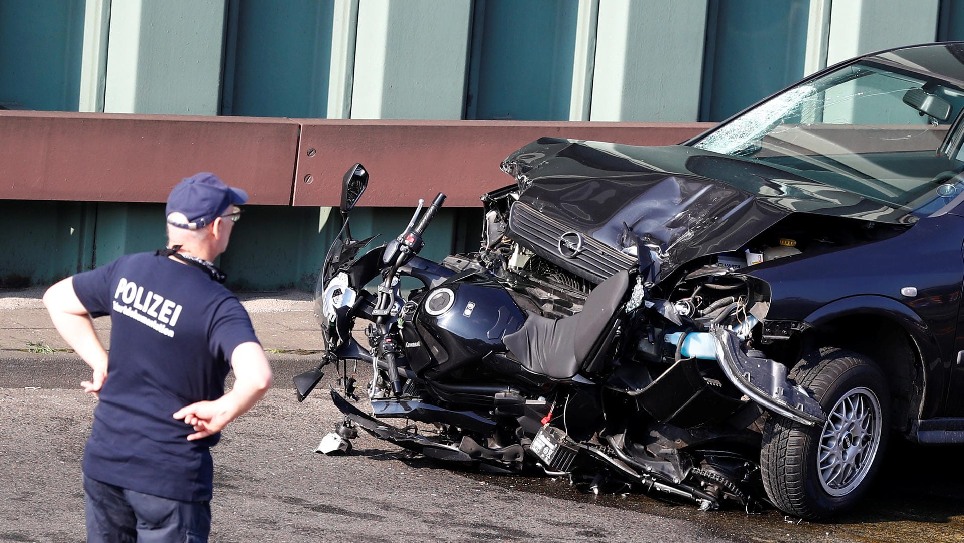 Polizeibeamter mit dem Wrack des Fahrzeugs: Auf der Berliner Stadtautobahn hat ein Mann mutmaßlich versucht, einen islamistisch motivierten Anschlag zu verüben.